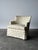 Cream chintz sprinkled with pink, mauve, and sage florals wraps this skirted vintage club chair from its curved back down...
