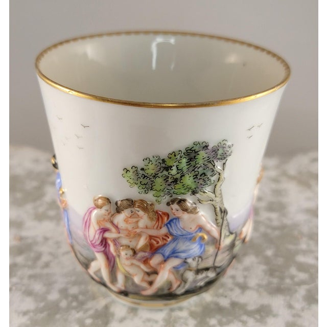 This 19th-century Capodimonte demitasse cup and saucer is a highly ornate, hand-painted piece of Italian porcelain. It is...