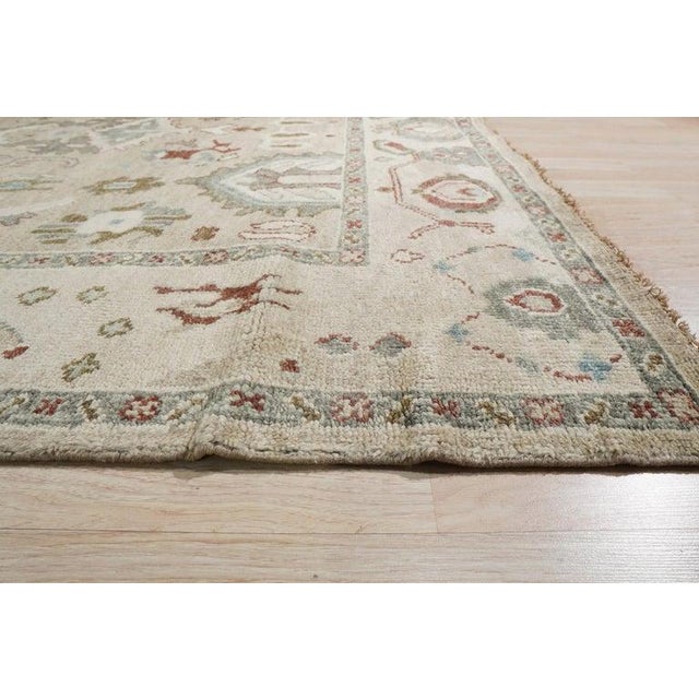 This hand knotted pile rug is crafted from wool and features a primary color palette of ivory, beige, cream, and white....