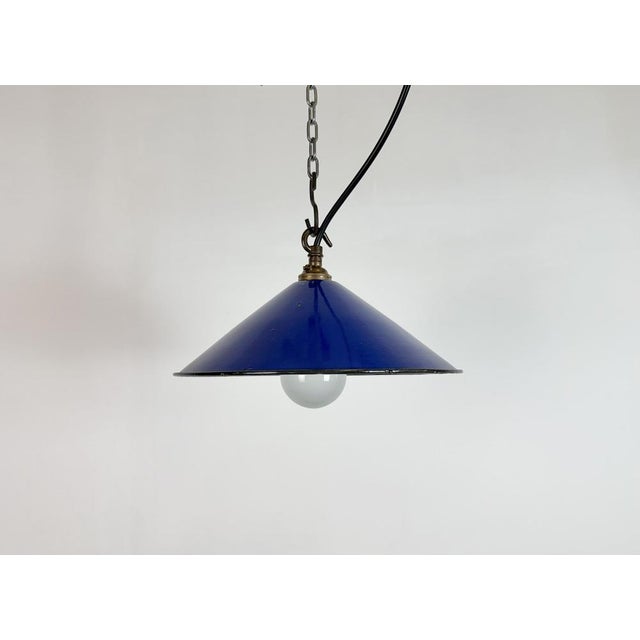 Industrial blue enamel factory pendant light made in United Kingdom during the 1950s. White enamel inside the shade. Brass...