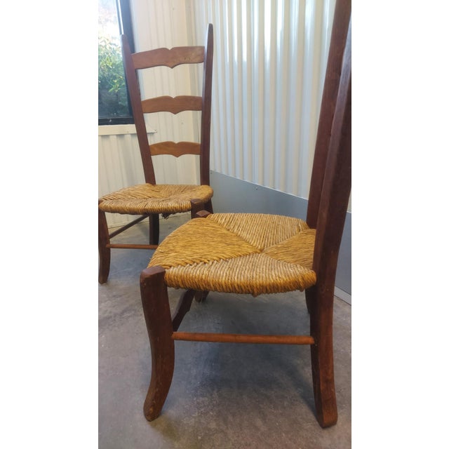 A lovely matched pair of antique French Provincial ladder-back nursing chairs, 19th century, in warm fruitwood (likely...