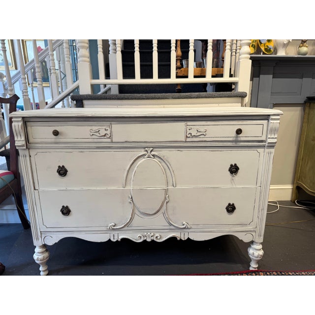 This is a vintage chest of drawers. It is hand painted white. It has fabulous carved details. It was made in France. It...