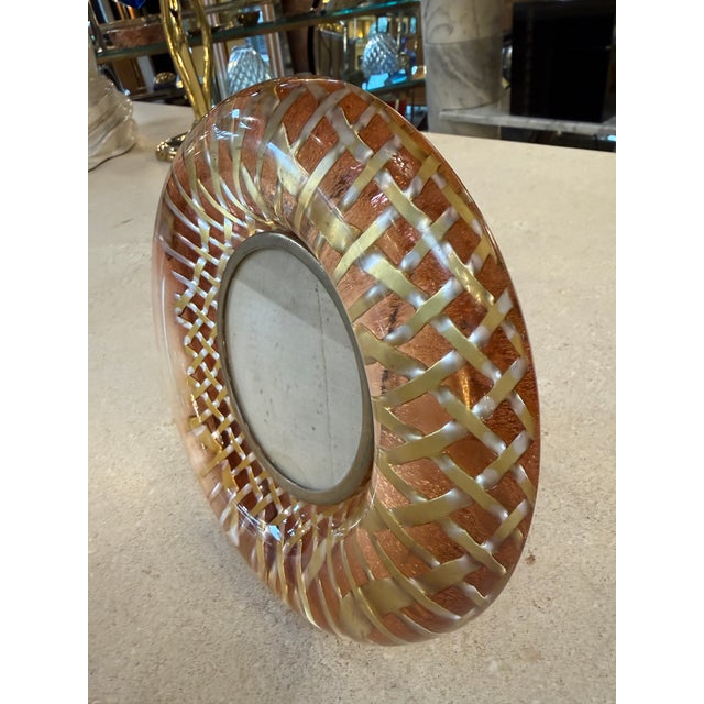 Distinctive Italian mid-century round picture frame, crafted in layered Lucite with a warm amber tone and an intricate...