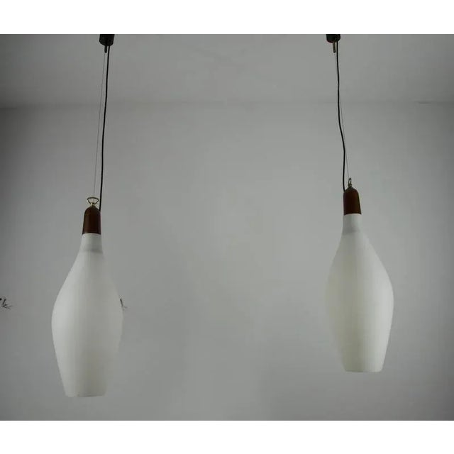 This elegant pair of mid-century pendant lamps from italy, dating back to the 1960s, perfectly captures the refined design...