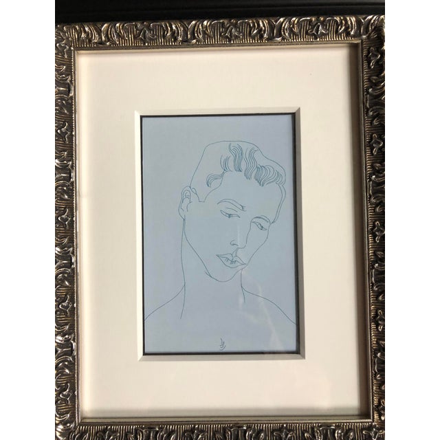 Andy Warhol postcard print of a male figure framed and matted in an ornate black and silver frame.