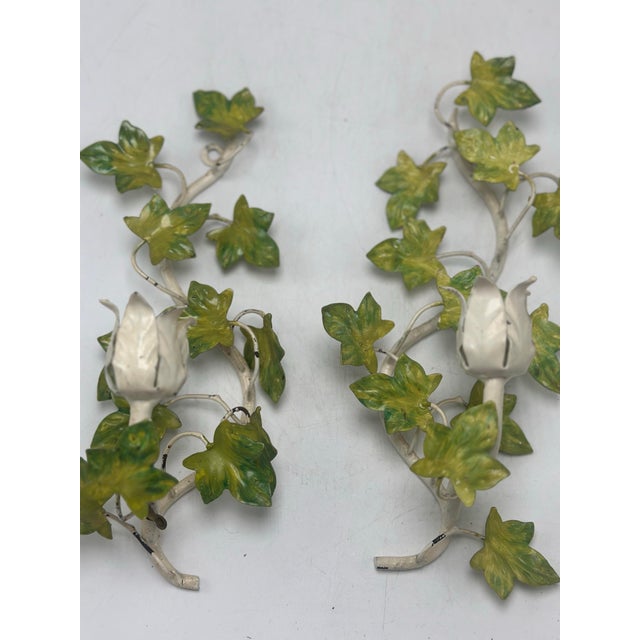 This is a vintage toleware wall sconce set, featuring a central double-arm sconce with two coordinating single sconces....