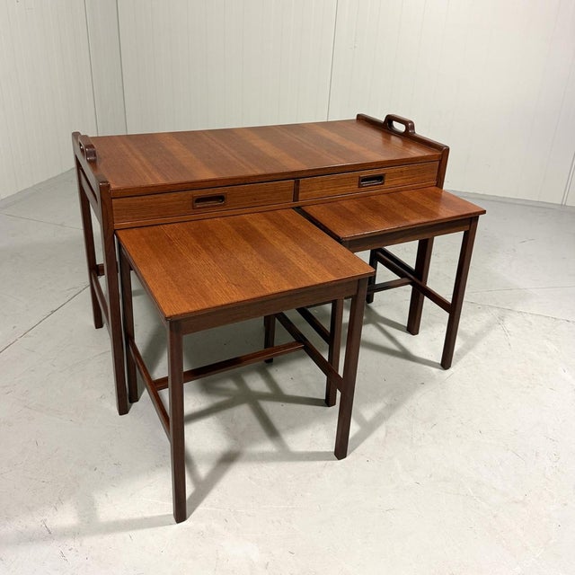 Teak nesting tables by Skaraborgs Möbelindustri, Sweden (marked). A large table with 2 drawers and 2 handles so it can be...