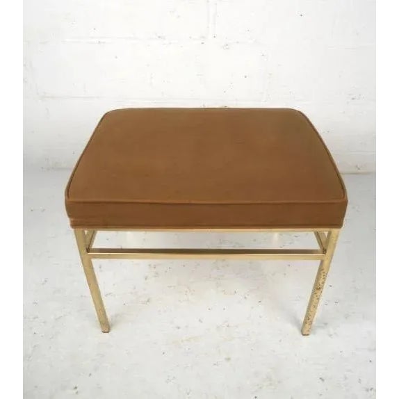 This hollywood regency style ottoman features a newer brown upholstery and brass base which offers elegant and comfortable...