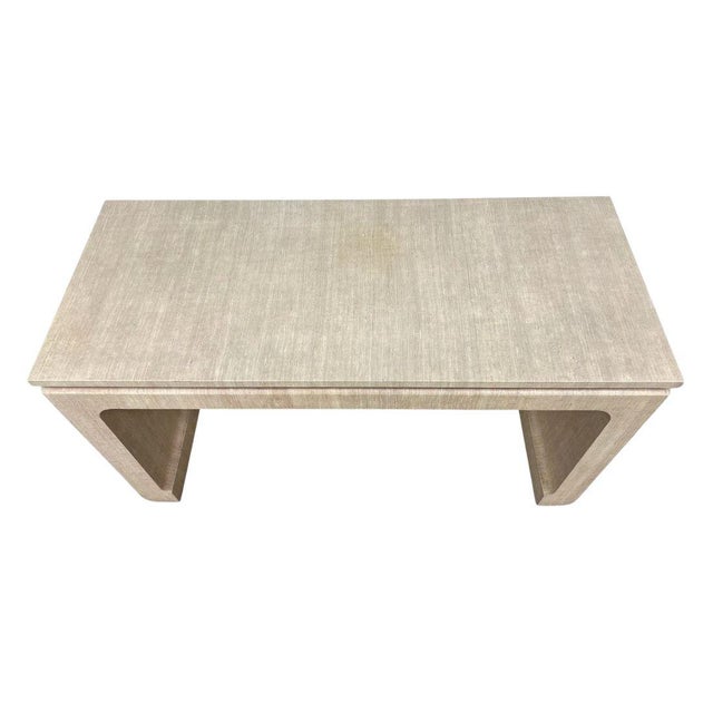 A Karl Springer style cream raffia wrapped low console table. Asian inspired and shaped with modern lines, a raised top...