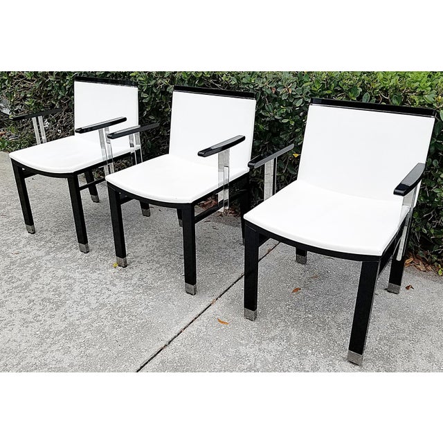 Modern Italian style exemplified in these chrome, piano black and white leather armchairs by noted maker, Pietro...
