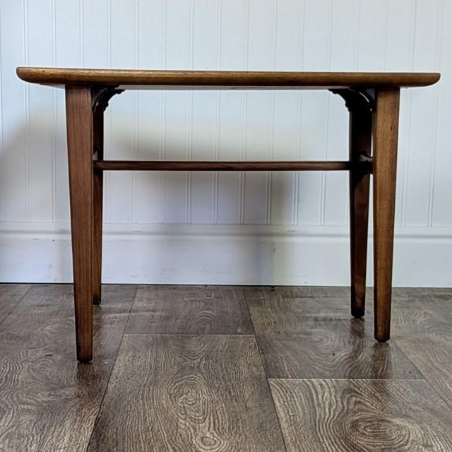 This vintage mid-century modern end table features a striking trapezoid-shaped top in bookmatched walnut veneer, sitting...