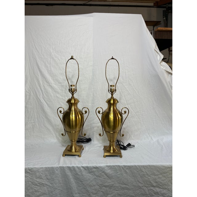 Beautiful Vintage Brass Urn Lamp Pair with minor wear and one dent in each of the lamps base. The lamps measure 30” to the...