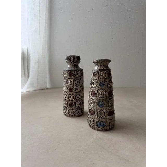 Two vases that are clearly related, yet each possesses its own distinct character. These ceramic vases were produced by...
