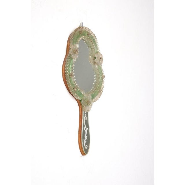 This vintage Italian Murano glass Venetian hand wall mirror is a charming example of traditional Venetian craftsmanship....