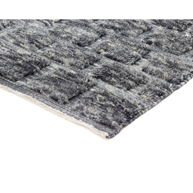 A dense, distressed charcoal field flecked with silver gray, its fine horizontal banding giving the surface a weathered,...