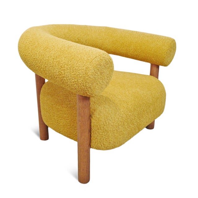 Modern unique mustard yellow poly upholstered accent chair. U-back design with sleek cylindrical oak wood post legs. Exact...