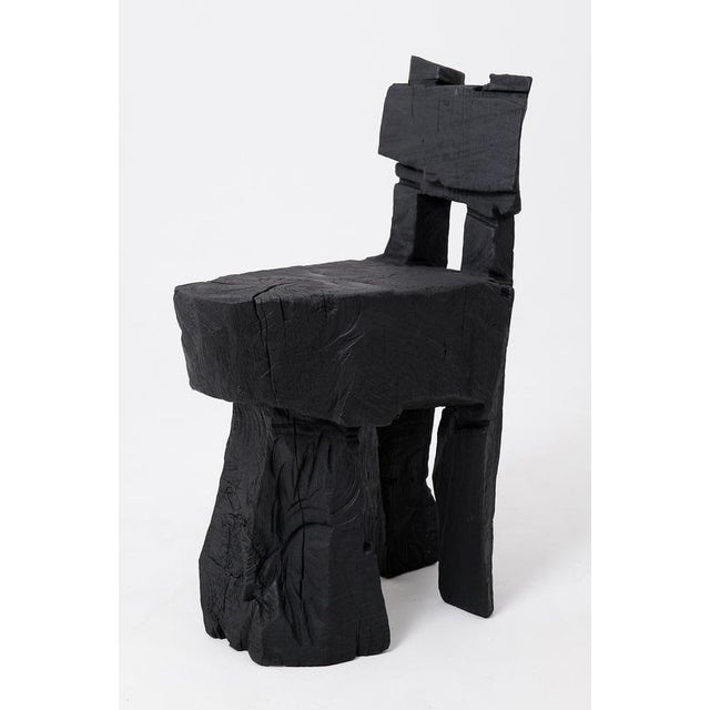 Carved from solid hardwood, this one-of-a-kind chair is a celebration of raw, elemental form. Its design features a heavy...