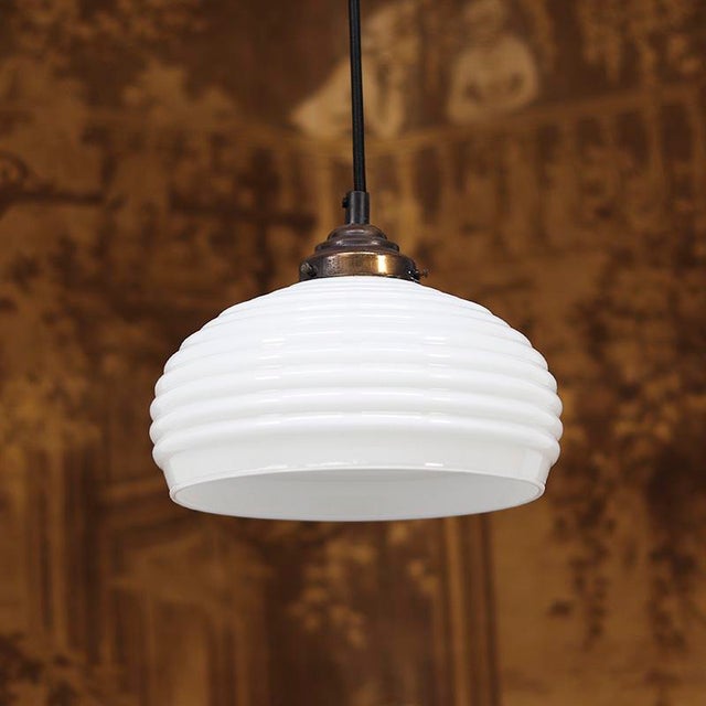 Extremely decorative hanging lamps in Art-Deco style. The lamps have a ribbed opaline glass shade. The shade holders are...