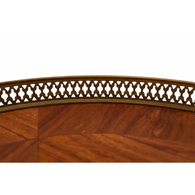 A classic Louis XV–style side table featuring richly figured kingwood veneer and detailed marquetry inlay throughout. The...