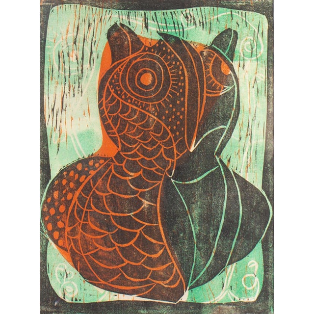 An abstract relief print of a bird. This print features a stylized bird, half green, half orange, sitting in front of a...