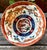 A striking Japanese Imari-style porcelain bowl featuring opposing dragons pursuing the sacred flaming pearl and a central...