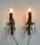 Petite bronze wall sconces with glass bobeches adorned with crystal drops. Black and gold drip candle covers. Torch top...