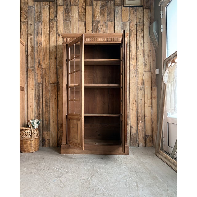 Large, bright, and understatedly elegant, this antique louis xvi style glass-fronted bookcase embodies the refinement of...