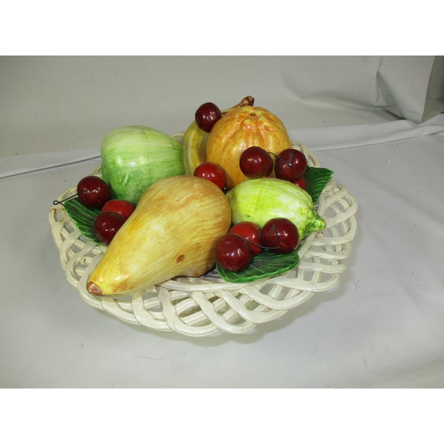 A decorative Italian ceramic, hand crafted white woven pedestal bowl of various colorful fruit. Display this piece on a...