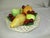 A decorative Italian ceramic, hand crafted white woven pedestal bowl of various colorful fruit. Display this piece on a...