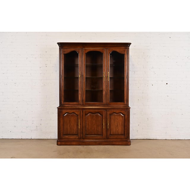 A gorgeous French Louis Philippe style lighted breakfront bookcase or dining cabinet By Kindel Furniture USA, Circa 1980s...