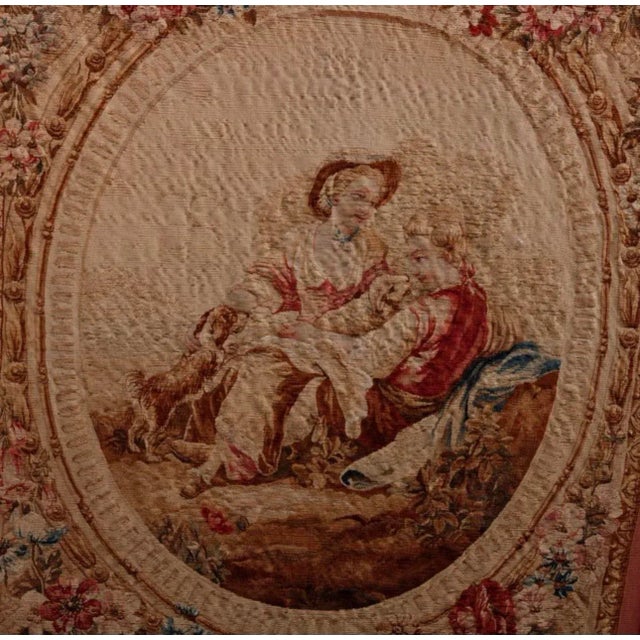 An antique French Louis XVI style fire screen offers a gilt wood frame with acorn finials having needlepoint front center...