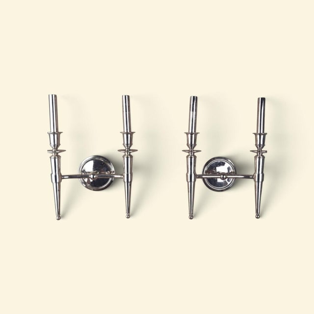 An elegant pair of Abington two-light wall sconces by Hudson Valley Lighting, featuring a polished nickel finish and...