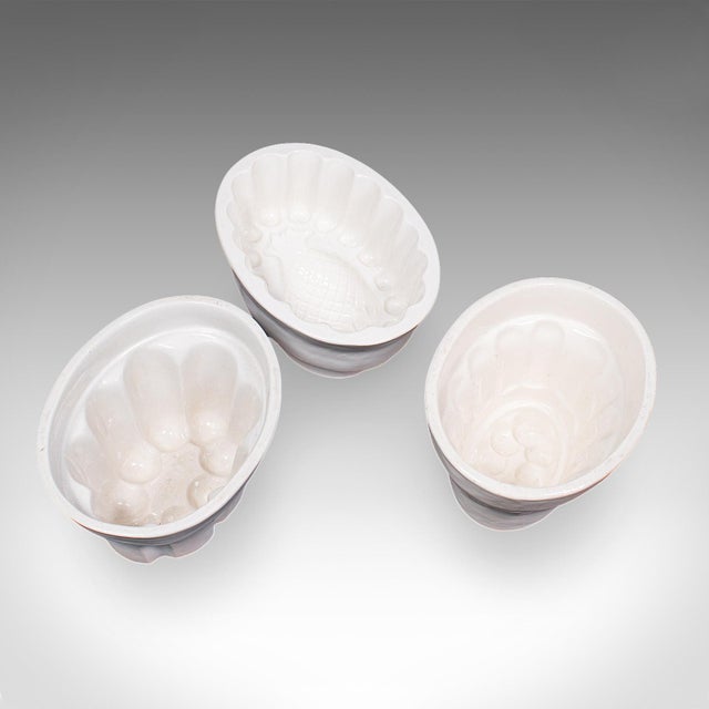 This is a set of three antique jelly moulds. An English, ceramic kitchen accessory trio, dating to the late Victorian...