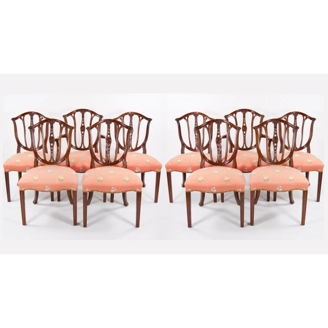 Transform your dining space with this exquisite Set of Ten Hepplewhite Style Dining Chairs, including two armchairs and...