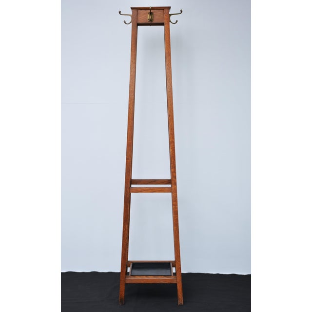 English industrial style solid oak coat stand, having four shaped double hooks to each side on four outswept supports...