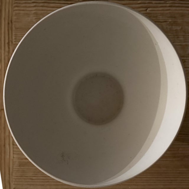 Crafted in Portugal for CB2, this sculptural pedestal bowl features a clean architectural silhouette elevated by a...