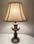 A neoclassical Hollywood Regency bronze trophy, cup earn style table, lamp, features and elegant, classical design with a...