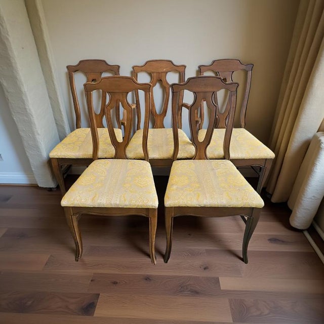 A handsome set of six vintage Chippendale-style dining chairs featuring pierced splat backs and elegant cabriole front...