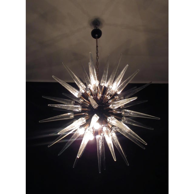 Italian Sputnik chandelier in a black and brass metal, 51 unobtainable transparent glass tips. Murano blown glass in a...