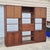 This is a handsome midcentury modern 3-bay wall unit made of walnut veneer with cane panel doors. The pieces are unsigned...