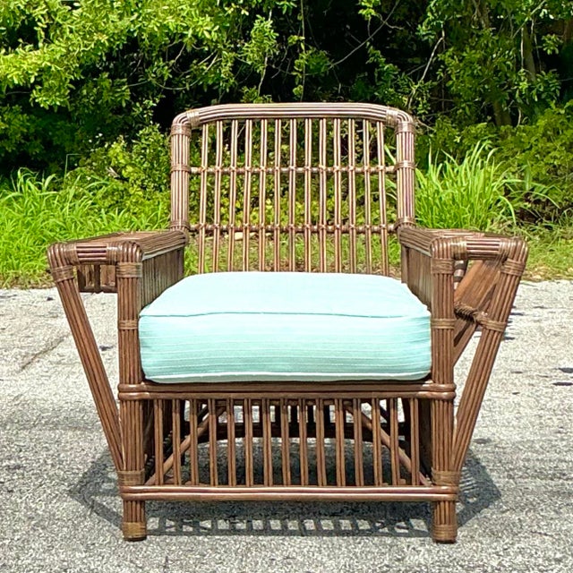 Experience timeless comfort with our American-style Vintage Coastal Palecek President’s Stick Rattan Lounge Chair....