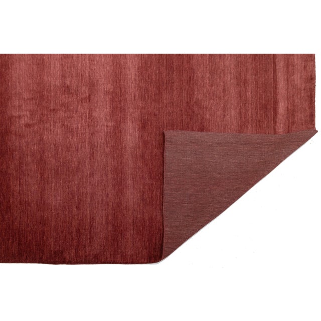Discover our stunning handcrafted Gabbeh-style wool rug, showcasing a rich Red Burgundy design. Proudly part of our Desert...