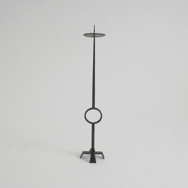 This wrought iron standing candle holder presents a striking, architectural silhouette. The floor-standing design features...