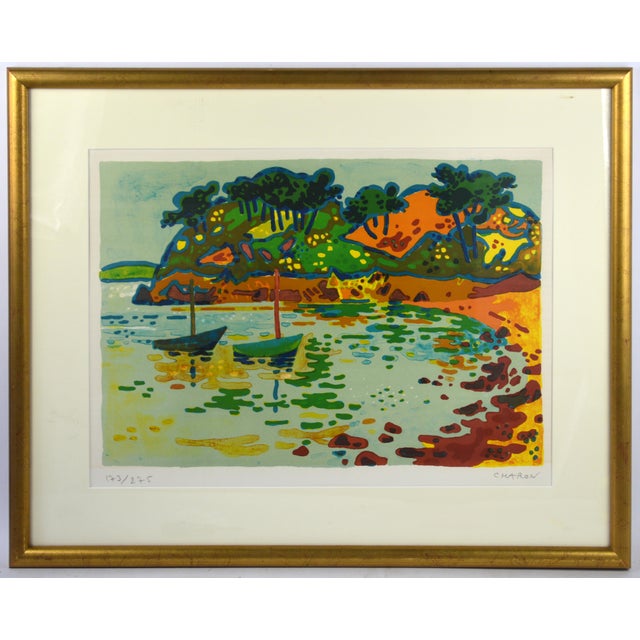 A festive and colorful rendition of a Brittany coastal bay by noted French artist Guy Charon. The work is titled "Crique...