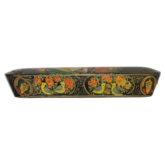A polychrome lacquer papier mache pen case. Qajar Iran 20 th century. With rounded ends and sliding tray, decorated all...