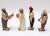 Crude hand-carved and painted wedding party figures (bride, groom, officiant - likely a preacher, and witness - presumably...