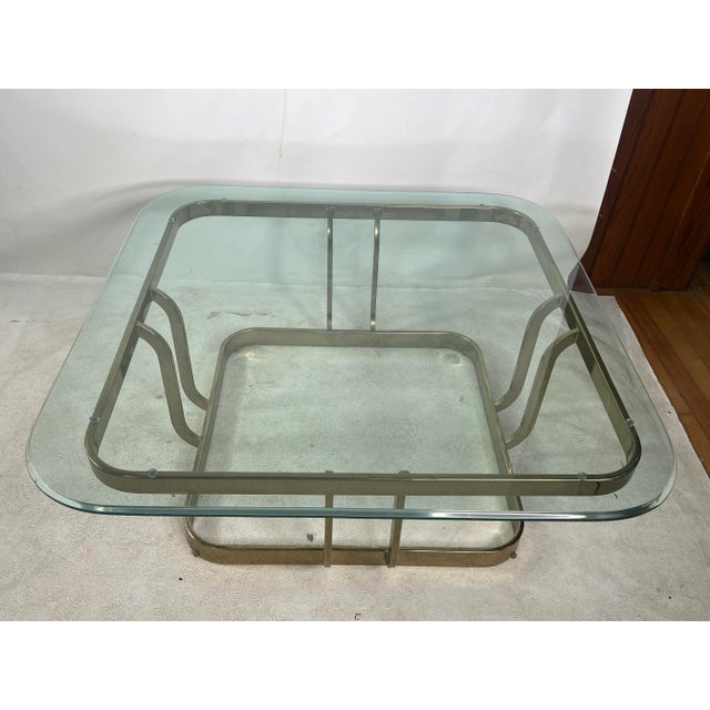 For sale is this nice mid century style coffee table made out of metal and glass. The table was made around the 80s