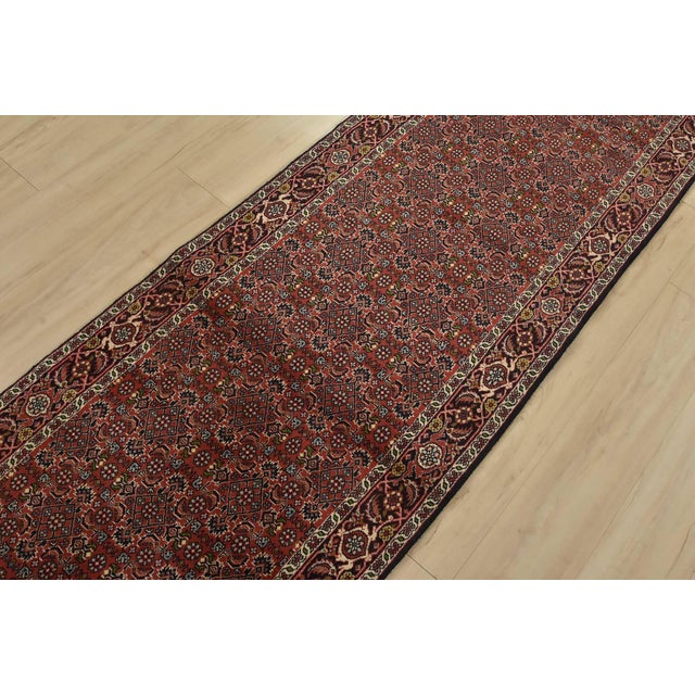 An authentic vintage traditional Bidjar runner hand-knotted with fine wool and natural dyes. This intricately woven...
