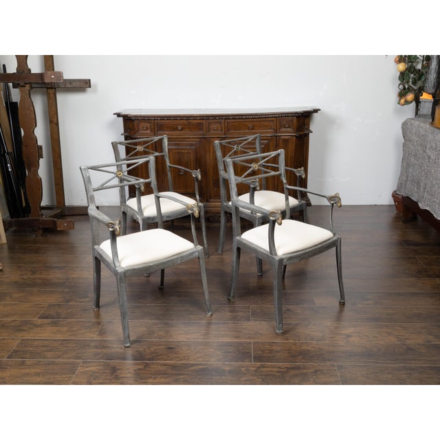 A set of four vintage Italian metal armchairs from the mid 20th century, with brass rams' heads and new upholstery....