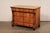 A French Neoclassical wooden four-drawer commode, with column accents, from the 19th century. This antique cabinet from...